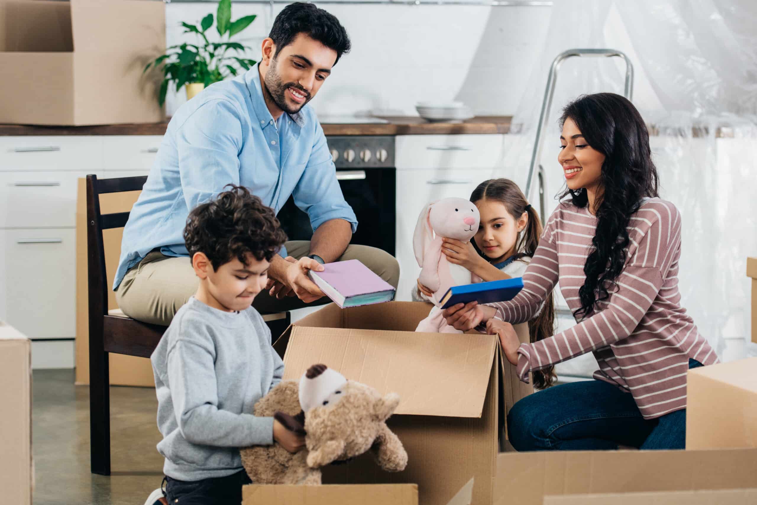 happy latin family unpacking boxes in new home